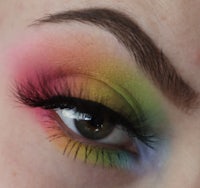 a close up of a woman's eye with colorful makeup