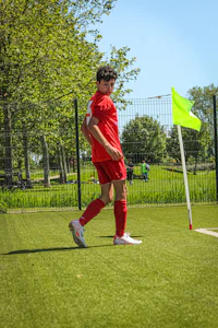 a man is playing soccer on a green field