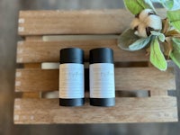 two sticks of deodorant sitting on top of a wooden crate