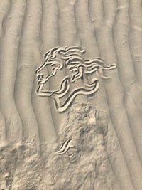 a woman's face is drawn in the sand
