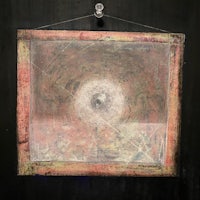 a painting hanging on a black wall