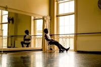 a person sitting in a chair in a dance studio