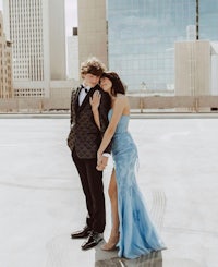 a man and woman posing for a photo on the roof of a building