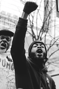 a black man holding up a sign in front of a crowd