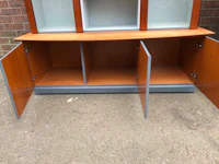 a wooden cabinet with glass doors and drawers