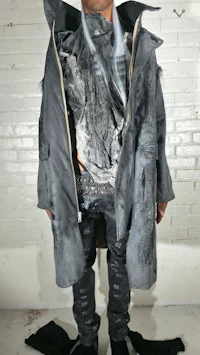 a man wearing a grey jacket and jeans