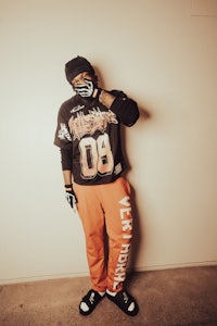 a man wearing a black hat and orange pants