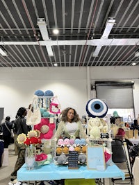a woman standing next to a table full of hats and teddy bears