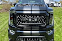 a black gmc sierra parked in a grassy field