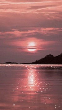 a pink sunset over a body of water