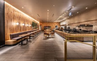 the interior of a coffee shop with wooden walls
