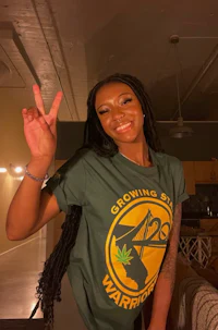 a woman wearing a green t - shirt with a peace sign