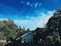 a blue sky with clouds and a house in the background