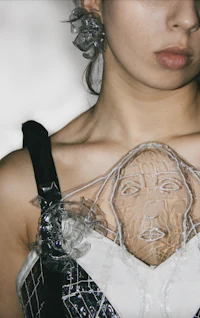 a woman wearing a dress with a plastic face on it