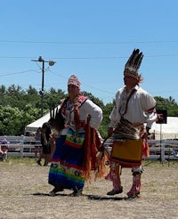 two native american dancers perform at a festival