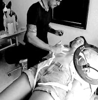 a man is putting a tattoo on a woman's body