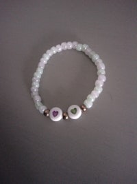 a bracelet with two green and purple beads on it