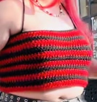 a woman wearing a red and black crocheted top