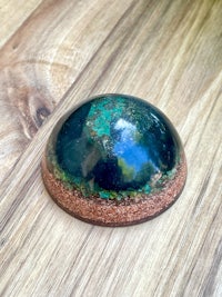 a blue and green stone on top of a wooden table