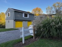 a gray house with yellow garage doors