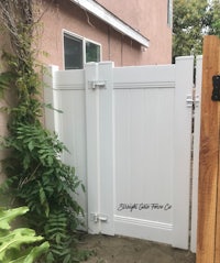 a white fence in a backyard with plants