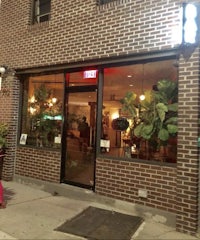 a woman is standing outside a restaurant at night