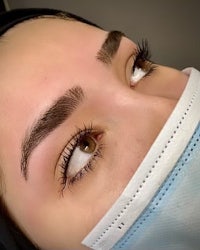a woman wearing a mask with her eyebrows