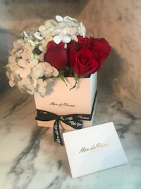 red roses and hydrangeas in a white box