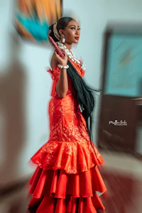 a woman in a red dress is posing in a room