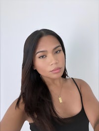 a woman wearing a black tank top and necklace