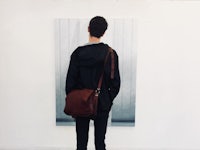 a man standing in front of a painting