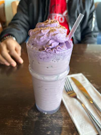 a person is sitting at a table with a drink