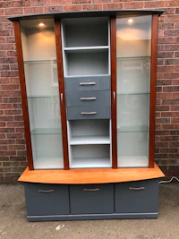 a display cabinet with glass doors and drawers