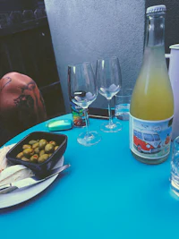 a table with a bottle of wine and a plate of food