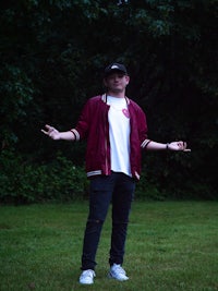 a man standing in a field with his arms outstretched