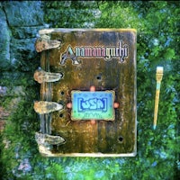 a book with a pen on it next to some moss