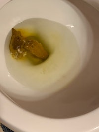 a toilet bowl with a piece of bread in it