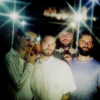 a group of men posing for a picture in a dark room