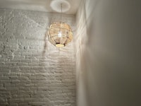 a light hanging from a brick wall in a room