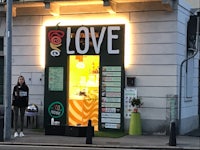 a woman standing in front of a store with a sign that says love