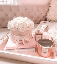 a pink tray with roses and books on it