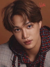 a young man wearing a plaid shirt and scarf
