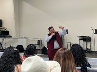 a man is speaking to a group of people in a church