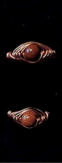 a pair of copper rings with brown stones on them