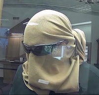 a man wearing a tan scarf and sunglasses in a bank