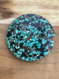 a turquoise stone plate on a wooden table