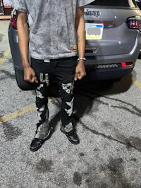a man standing in front of a car in a parking lot