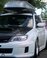 a white subaru wrx with a roof rack on top