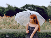 a girl with red hair holding a clear umbrella