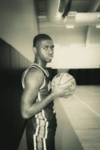a black and white photo of a basketball player holding a ball